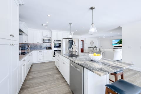 Fully equipped chef's kitchen featuring stainless steel appliances, granite counters, and ample prep space