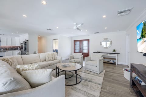 Spacious open-concept living room with soft coastal tones and plenty of seating for the whole group to gather