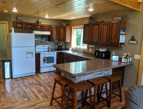 Kitchen with peninsula, full-size refrigerator, and stove