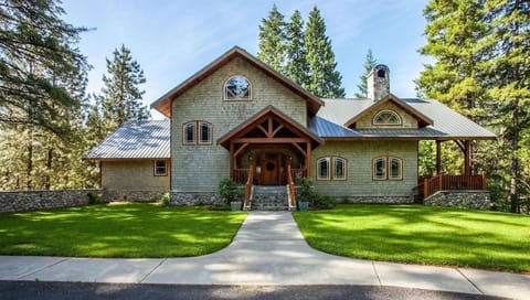 Rustic mountain lodge with lush lawn and serene forest setting