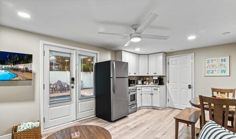 From the living space, the kitchen stands ready with modern appliances, cabinetry, and a subtle coastal palette.