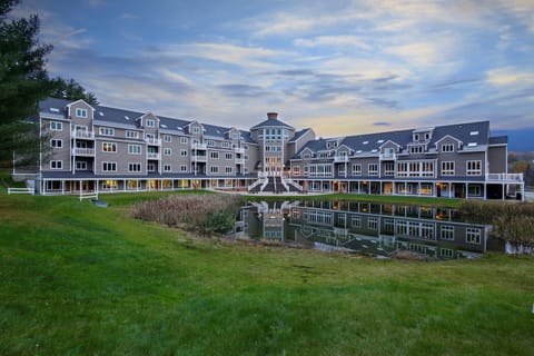Resort exterior with mountain views and pond.