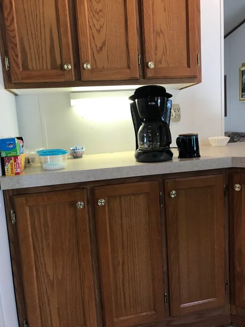 This is a view of the coffee pot next to the fridge.