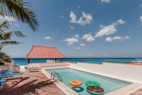 Large pool and beach area with loungers and ocean entrance