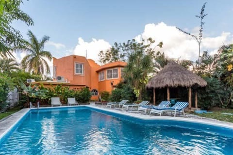 The large backyard has a pool, lots of seating, and a small shaded outdoor eating area