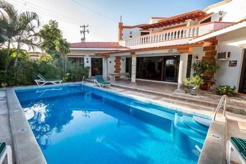 The pool is surrounded by lush gardens