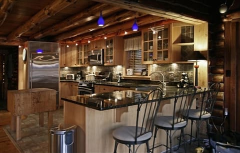 A state of the art kitchen, granite counters. gas stove and subzero refrigerator