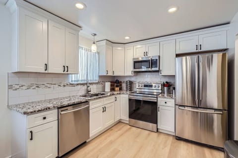 Stylish white shaker cabinets, granite counters and stainless steel appliances.