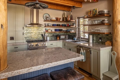 This rustic-modern kitchen invites you to create memorable meals with granite counters, professional appliances, and charming exposed beams overhead.