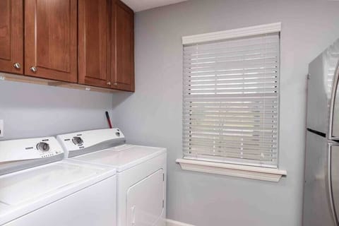 Laundry area with a full size washer and dryer. Laundry detergent and dryer sheets are provided.