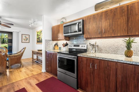 Your fully equipped kitchen features warm Koa wood cabinets, granite counters, and stainless appliances—perfect for preparing tropical meals.