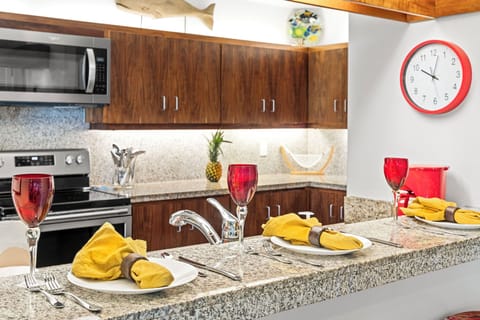 The fully equipped kitchen features granite counters, quality appliances, and elegant table settings for memorable meals.