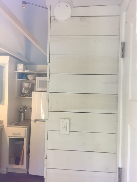 A view inside to the  kitchen,  planked bath wall and closet door. 