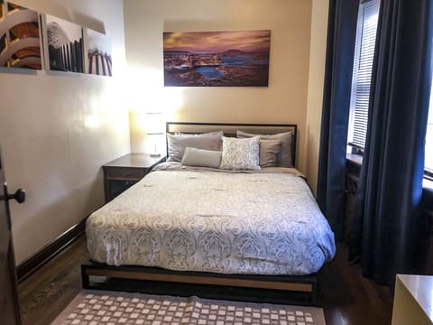 Bedroom #1 is a Queen bed, two lamps, a fan and power strip at the nightstand. 