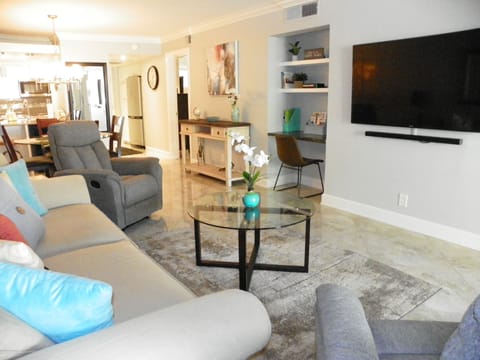 Comfortable bright living room with 60-inch Smart TV and sound bar