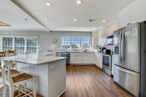 Your fully-equipped chef's kitchen features gleaming stainless appliances, a spacious island for meal prep, and abundant natural light streaming through large windows—perfect for gathering and creating memorable meals together.