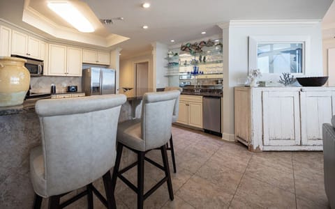 The kitchen features granite countertops, stainless appliances, and a stylish wet bar, perfect for entertaining
