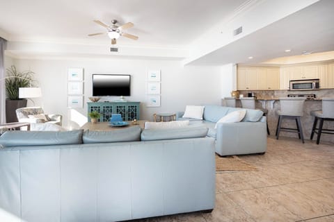 The living space features a large TV, comfortable seating, and a stylish blue accent table, perfect for relaxation