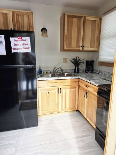 Kitchen has pots, pans, dishes and utensils to whip a meal.