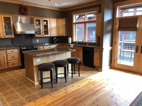 Fully stocked kitchen with island, upgraded appliances, and balcony