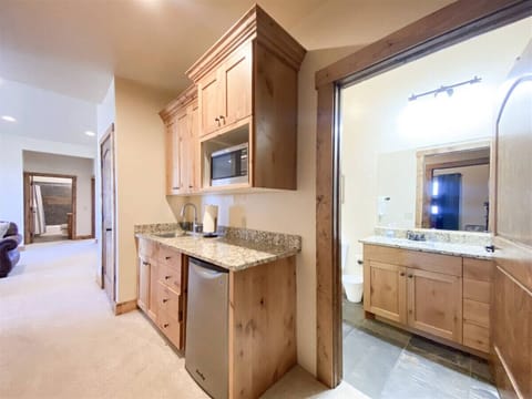 Convenient kitchenette and bath setup with granite finishes, perfect for guest comfort and easy refreshment