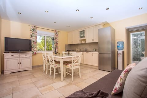Air-conditioned and fully equipped kitchen with dining area, a sofa and a TV