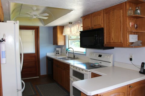 Spacious kitchen fully stocked: dishes, pots, pans, utensils, & spices.