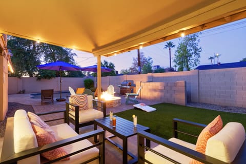 Private backyard oasis featuring heated pool, sun loungers, yard games, BBQ grill, and fire pit.