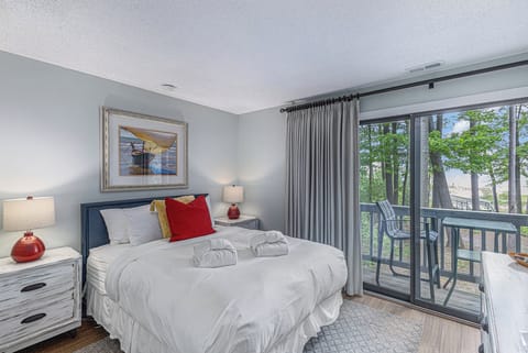 Wake to the sounds of birdsong and gentle waves in this cozy second-floor condo overlooking a tranquil stream—just steps from 600 feet of private beachfront on East Grand Traverse Bay.