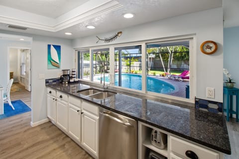 Kitchen overlooks pool and has sliding pass-through window