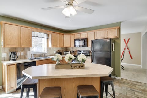 Large, fully stocked kitchen with island and sliding door to private deck