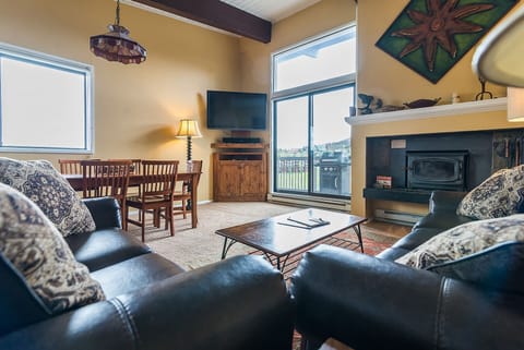 Sink into plush leather seating by your cozy fireplace, where warm light and mountain views create the perfect retreat.