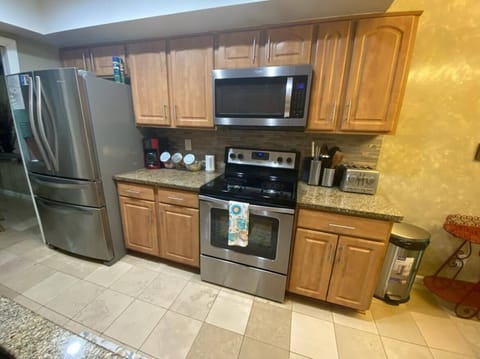 The kitchen has a built-in microwave, refrigerator, cabinets, and coffee pot.