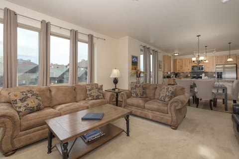 Sink into plush sofas in your spacious living room, where natural light floods through expansive windows and your open kitchen awaits culinary adventures.