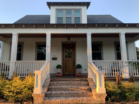 Front of house with porch, swing, and rocking chairs 