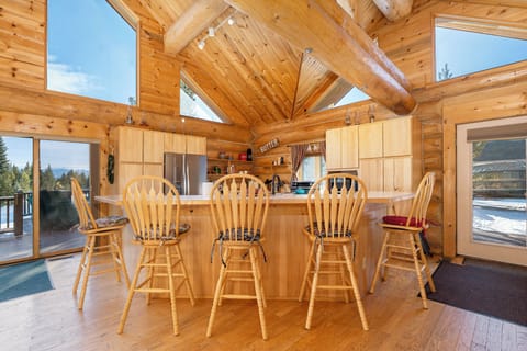 Gather around this stunning wooden kitchen island where rustic charm meets modern convenience in your mountain retreat.