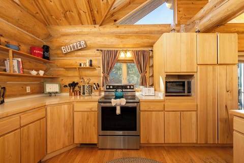Your rustic log cabin kitchen features modern appliances and soaring ceilings that create an airy, mountain retreat atmosphere for memorable meals.