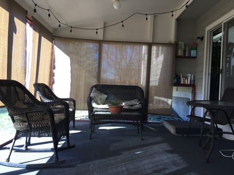Outside lawn furniture in screened in room with grill
