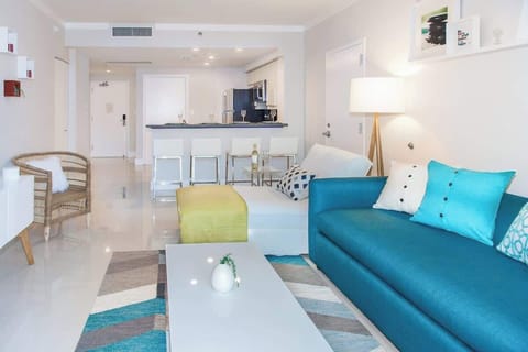 View of the living room and the main kitchen in the background. Large, well lit.