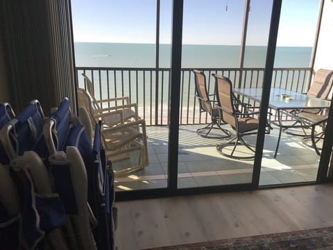 New patio table and swivel chairs on screened balcony that opens to living room.
