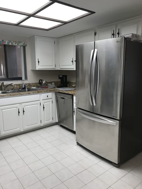 Kitchen with double stainless sinks, GE dishwasher, and large LG refrigerator.