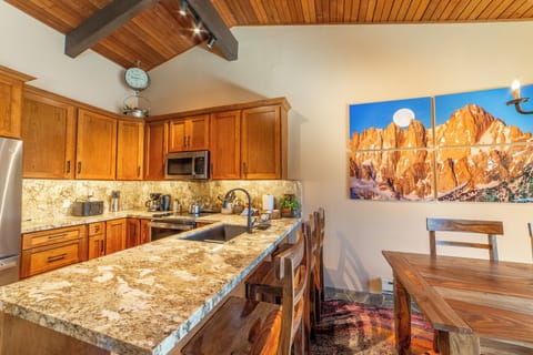 Kitchen and dining area w/ bar seating.