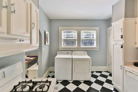 Washer and dryer in the kitchen, gas stove to your left and to the right is the kitchen sink, microwave, and dishwasher