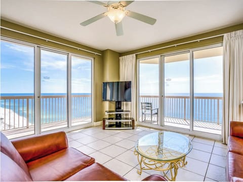 Unwind in this sun-drenched living room where floor-to-ceiling windows frame endless ocean views, creating your perfect beachfront sanctuary.