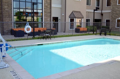 Outdoor swimming pool with bright poolside seating, just moments from SeaWorld San Antonio
