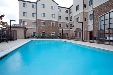 Outdoor pool with lounge chairs and patio seating on the deck — open seasonally for all guests