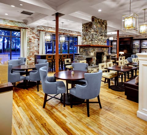 Bright breakfast and dining lounge with tables, chairs, and a warm, inviting atmosphere.