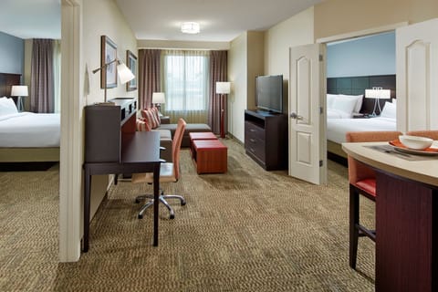 Spacious living area with workspace and comfortable seating arrangements.