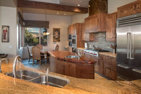 The modern chefs kitchen has Sub Zero, Viking and Dacor appliance with a dining table for 6