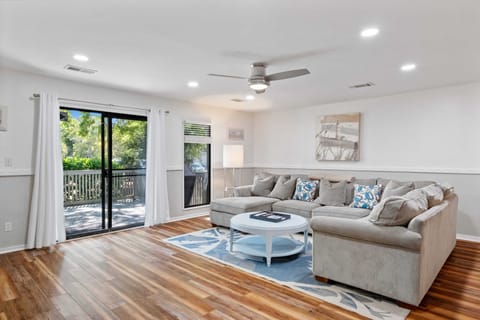 Spacious living room with access to the deck with 75 inch smart tv and cable.
